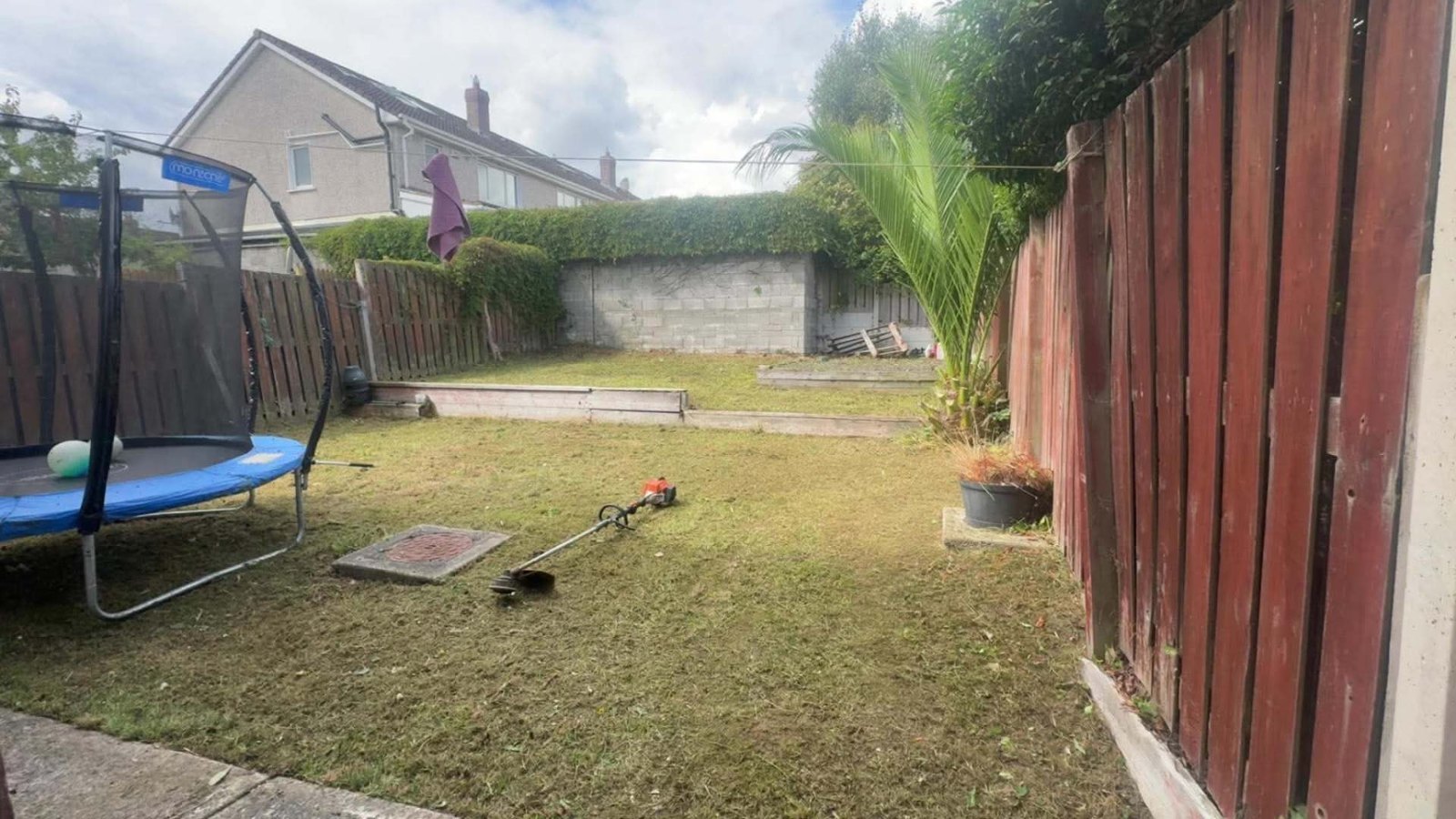 Same back garden cut back to a neat level lawn with the cuttings cleared away